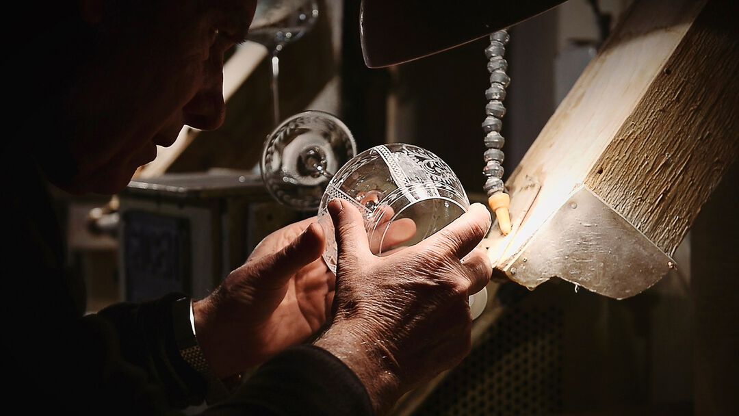 the craftsman working on the engraving of a glass