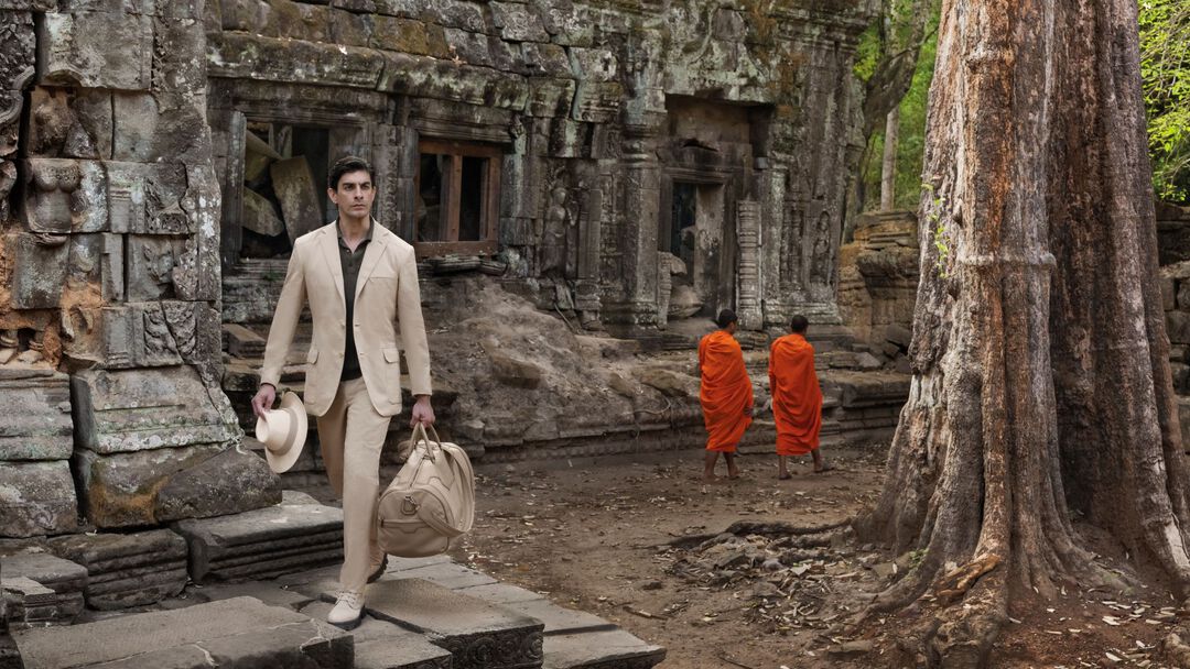 the model walking outside a Cambodian temple