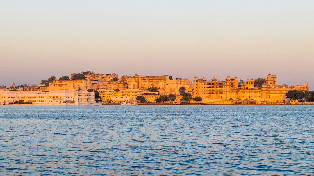 The golden skyline of Udaipur embraces the majestic Maharaja&rsquo;s Palace, a reflection of timeless beauty and history.
