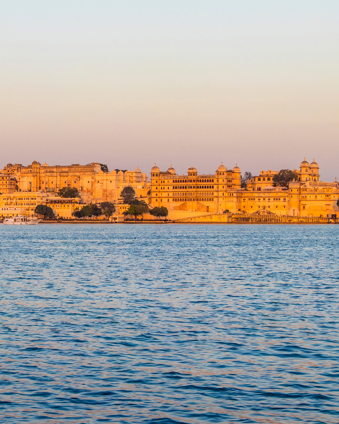The golden skyline of Udaipur embraces the majestic Maharaja&rsquo;s Palace, a reflection of timeless beauty and history.