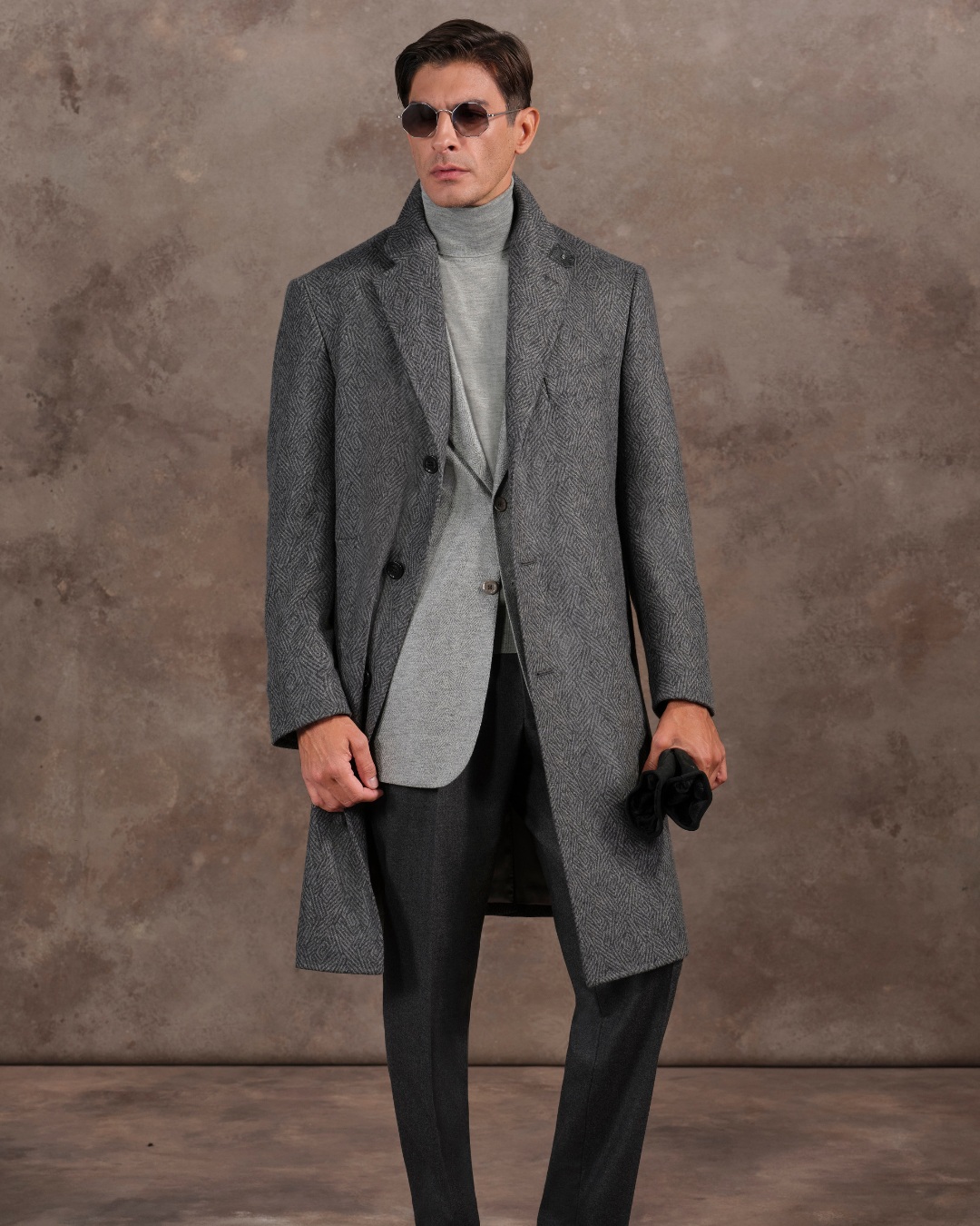 The model wears a refined ensemble featuring a deconstructed threebutton coat in pure cashmere layered over a timeless Fiesole jacket and a luxurious cashmere and silk turtleneck.