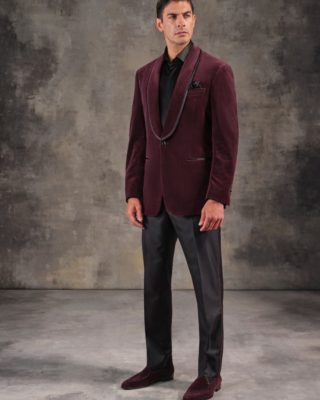 The model wears a velvet cocktail jacket paired with a fine silk tuxedo shirt and evening trousers.