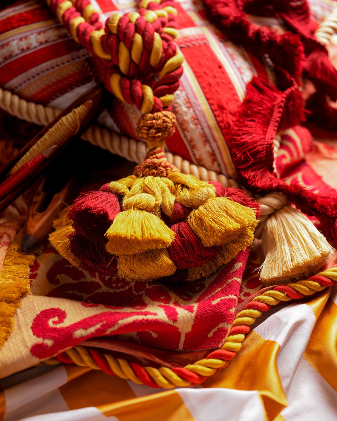 Handmade creations by the artisans of the Antico Setificio Fiorentino: the silk embrasse with tassel rests on a galloned cushion.