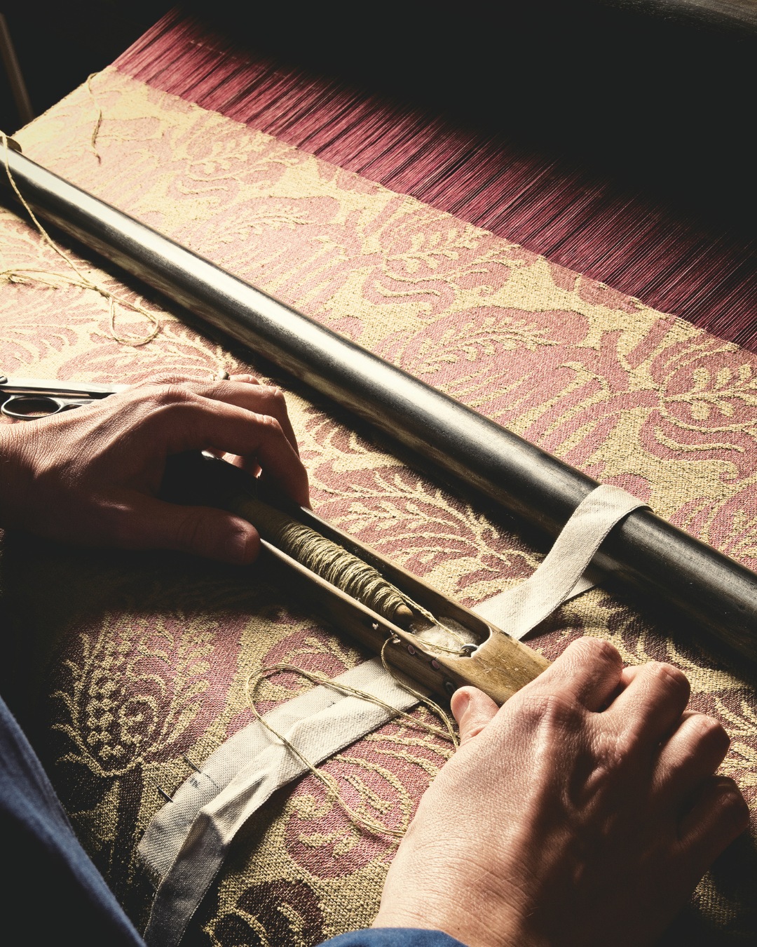 Changing a spool during the creation of the Doria damask on a handloom.
