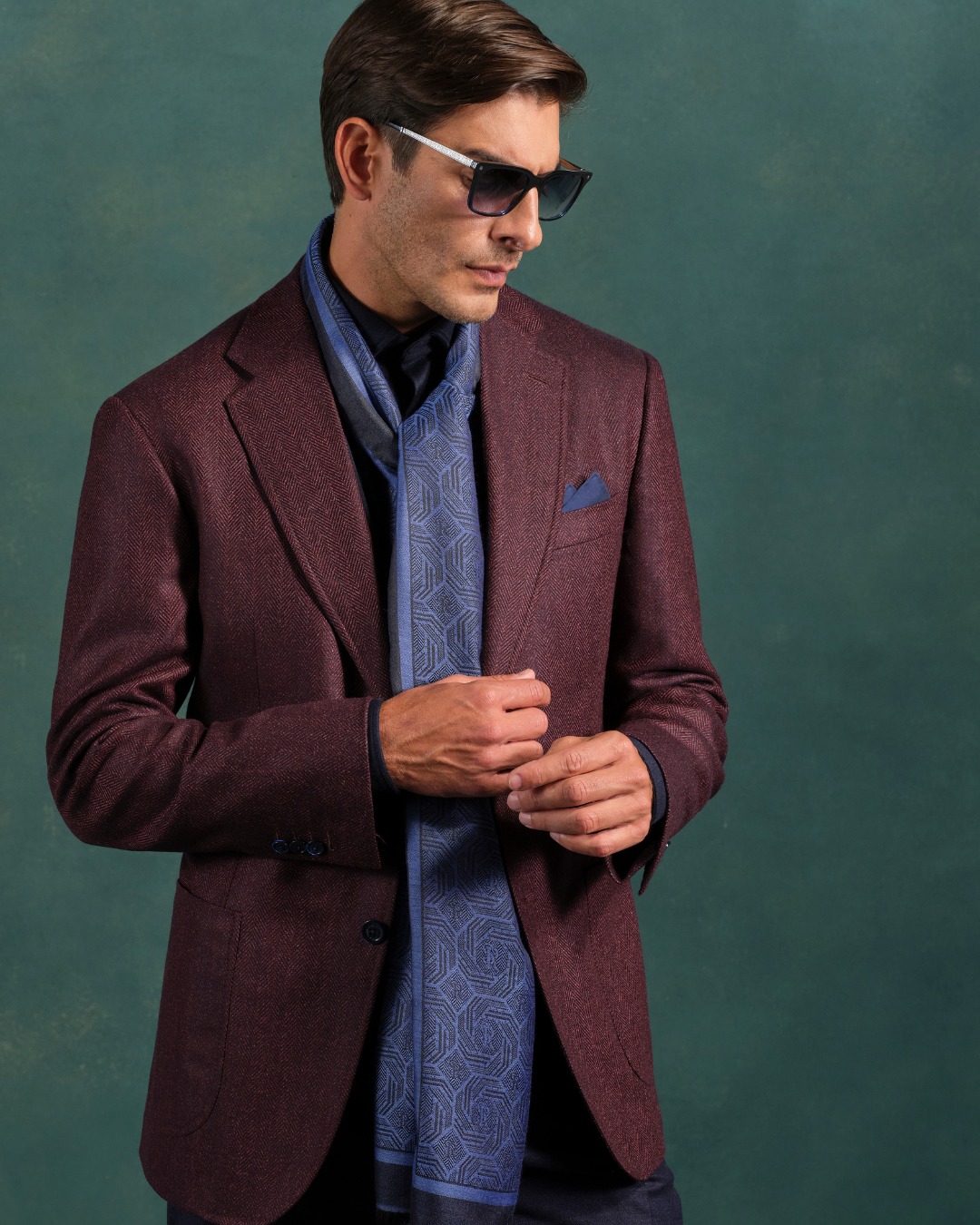 The model wears a deconstructed jacket crafted from fine wool and silk, paired with a pure silk shirt and versatile wool and cotton trousers